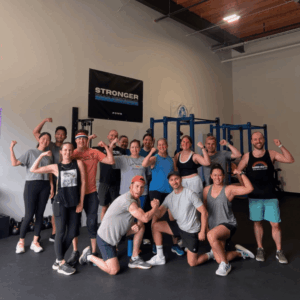POWR members flexing and smiling together in front of the Stronger Than Yesterday banner
