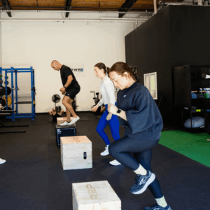 POWR members powering through box jumps on the studio turf